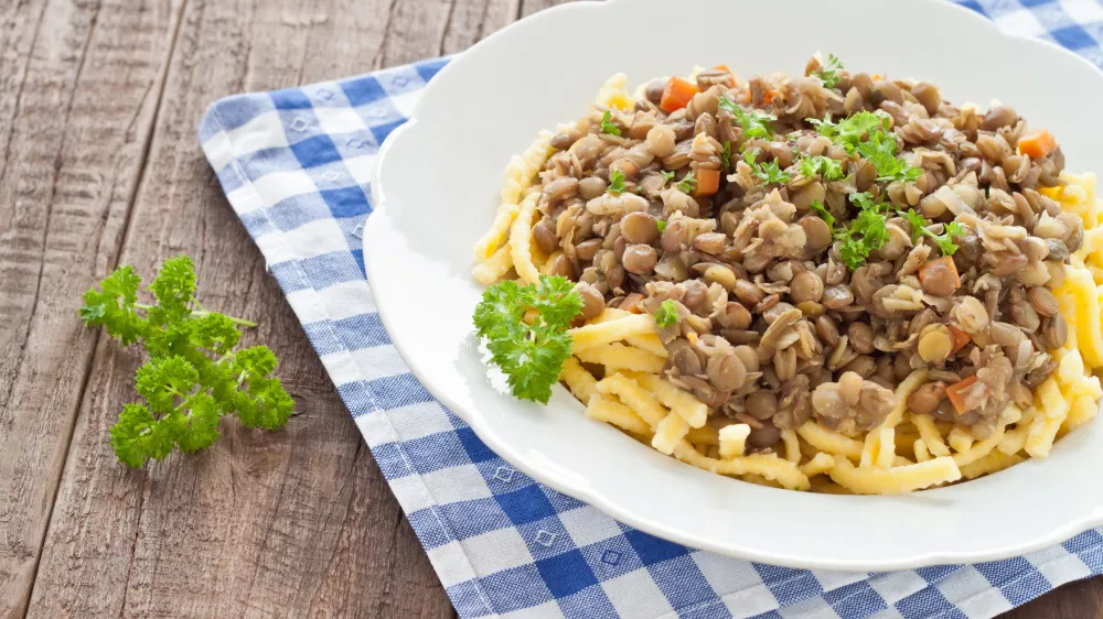 Klassische schwäbische Linsen mit Spätzle und Würstchen auf einem Teller