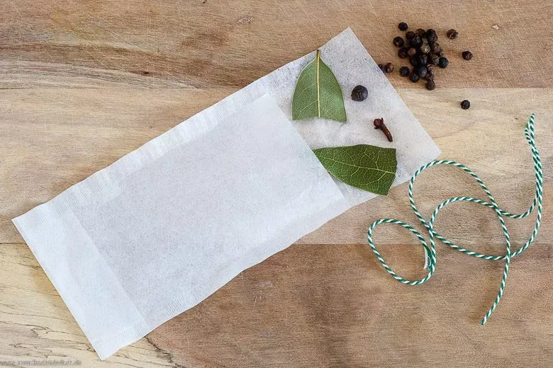 Klassische Suppengewürze wie Lorbeerblatt und Pfefferkörner in einem Teefilter, ein einfacher Trick für Anfänger beim Suppe kochen.