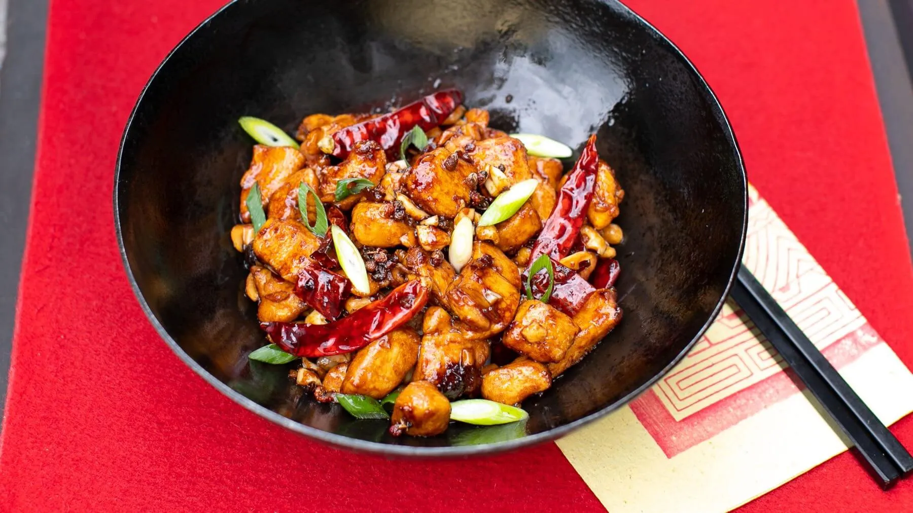 Klassisches Kung Pao Huhn mit Erdnüssen, Gemüse und Chilis in würziger Sauce, ein beliebtes chinesisches Rezept mit Huhn
