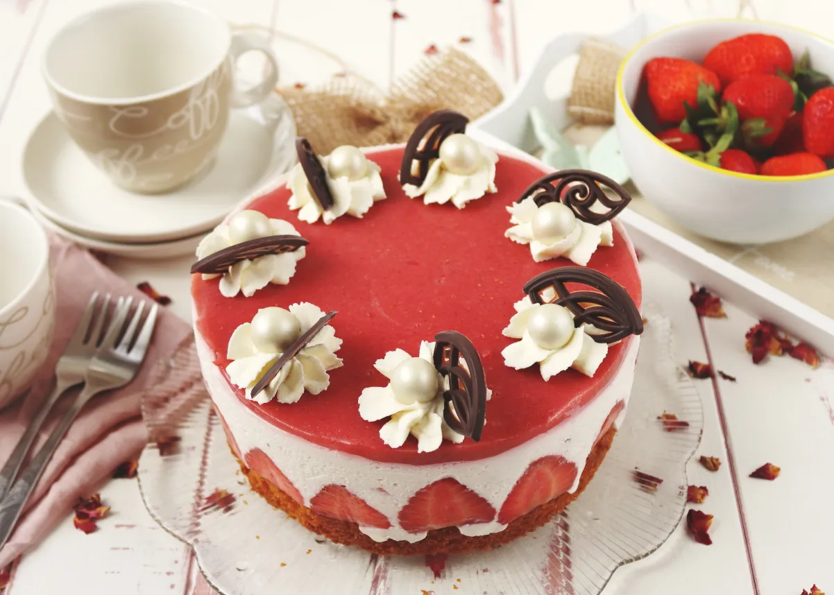 Kleine Erdbeer-Sahne-Torte mit frischen Erdbeeren und Dekoration