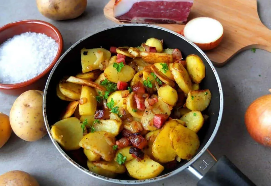 Knusprige Bratkartoffeln mit Speck und Zwiebeln in einer Pfanne