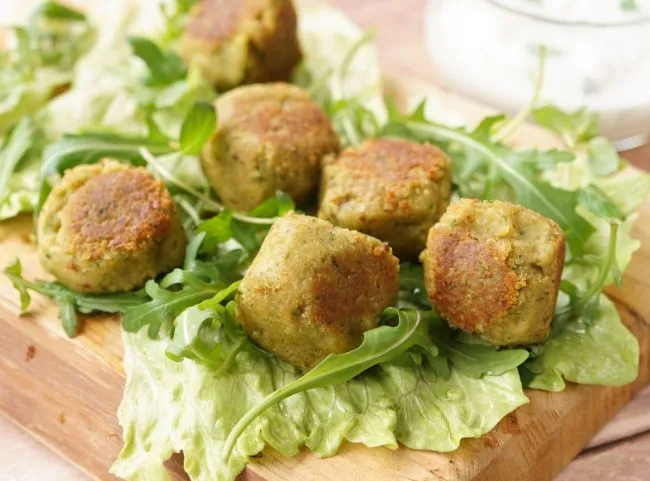 Knusprige Falafelbällchen, serviert mit frischem Salat und Soße.