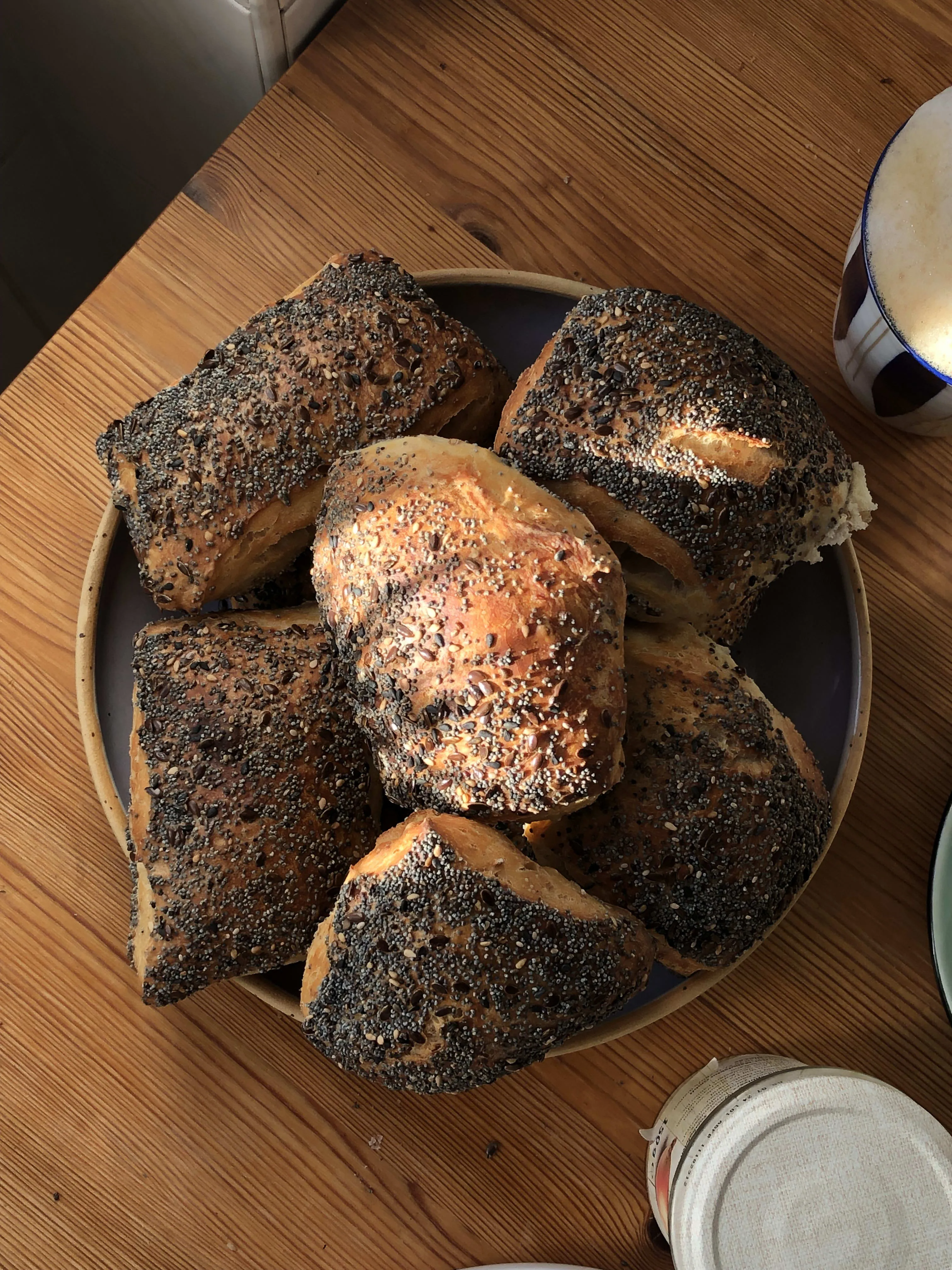 Knusprige Sonntagsbrötchen frisch aus dem Ofen auf einem Backrost, bereit für vielfältige Beläge beim deutschen Frühstück