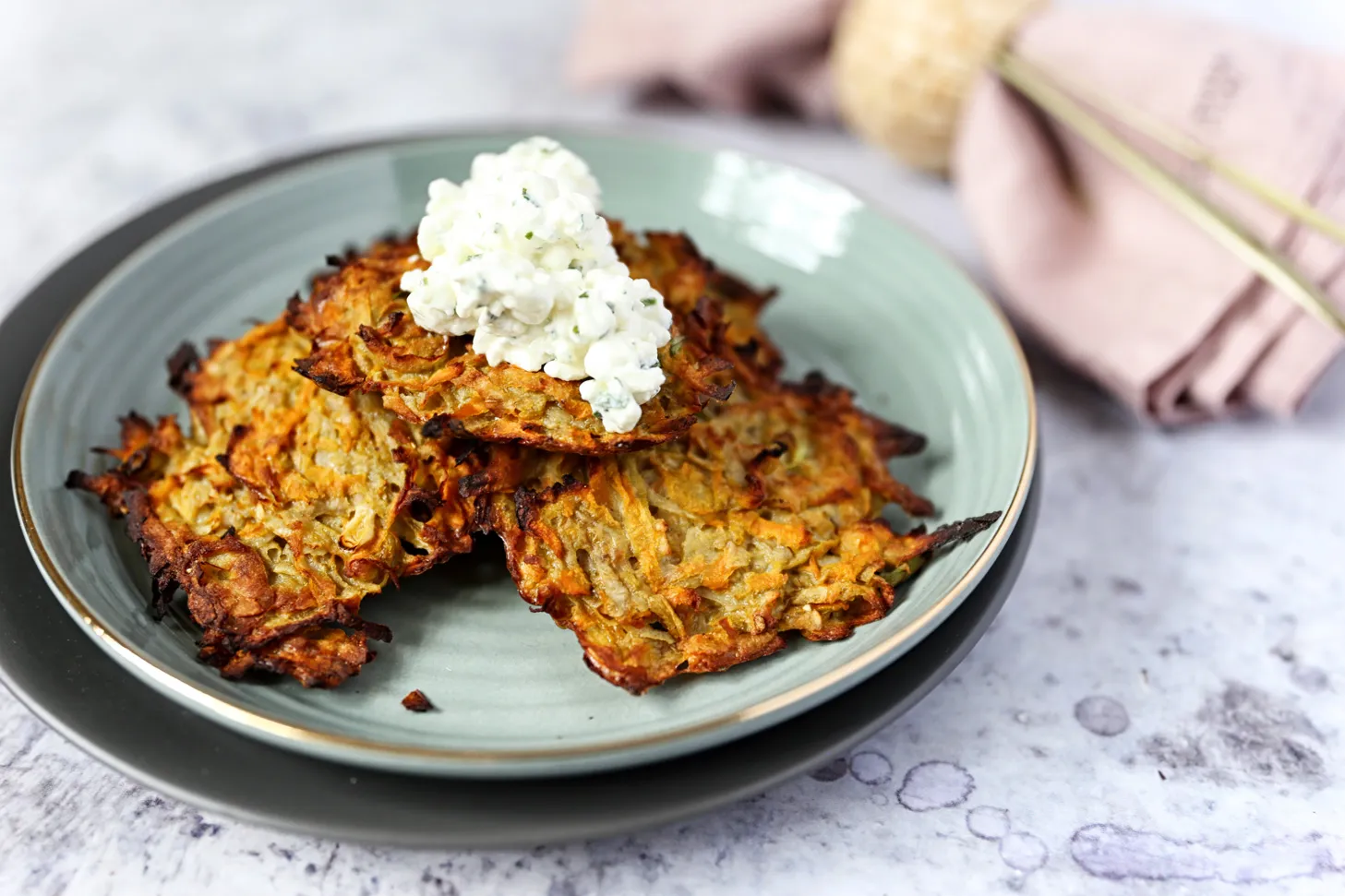 Knusprige Topinambur Röstis mit frischem Kräuterdip auf einem Teller angerichtet, perfekt für ein gesundes Mittagessen.
