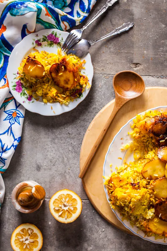 Knuspriger goldbrauner Tahdig mit Kartoffelscheiben am Boden eines Reistopfs