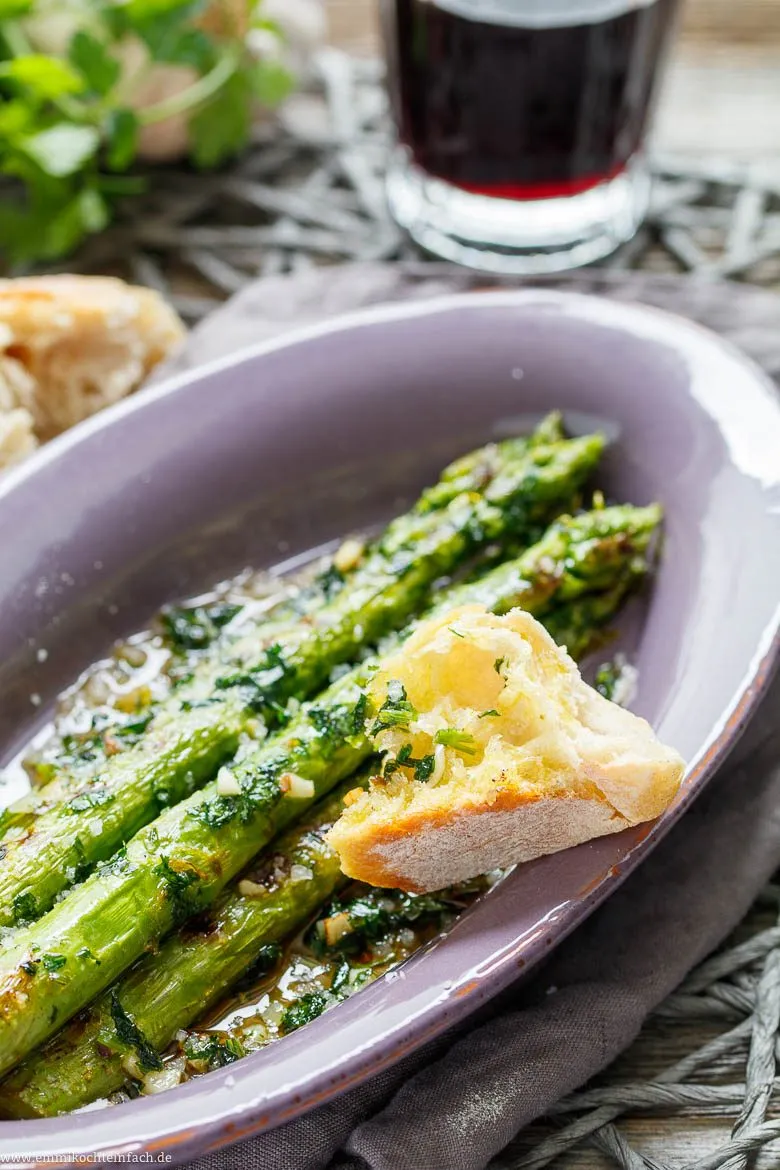 Knuspriges Baguette wird zusammen mit gebratenem grünen Spargel im Tapas-Stil serviert, ideal zum Dippen.