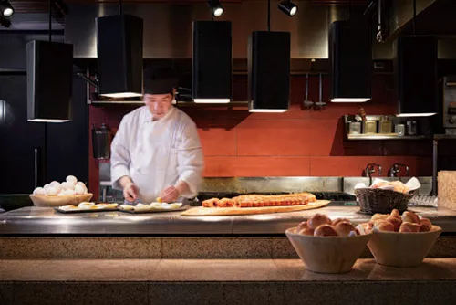 Koch bereitet Speisen in der Live Kitchen des Hotel Agora Osaka Moriguchi zu