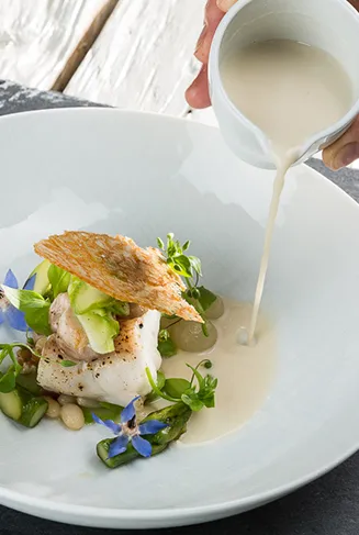 Kochschule im Huberwirt: Zwei Kochtöpfe auf dem Herd, im Hintergrund Utensilien