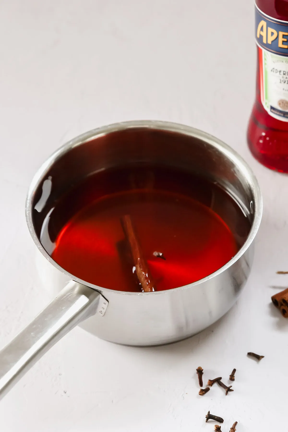 Kochzutaten für Weihnachts-Punsch in kleinem Topf.