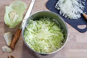 Kohl und Zwiebeln kleinschneiden.