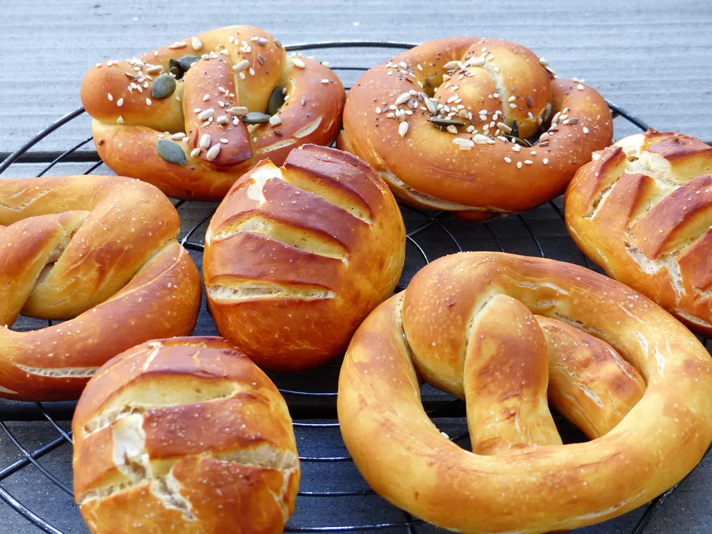 Korb gefüllt mit frisch gebackenen, glänzenden Laugenbrötchen und Brezeln