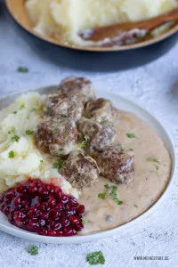 Köstliche Köttbullar-Fleischbällchen mit cremigem Kartoffelpüree und Preiselbeeren angerichtet