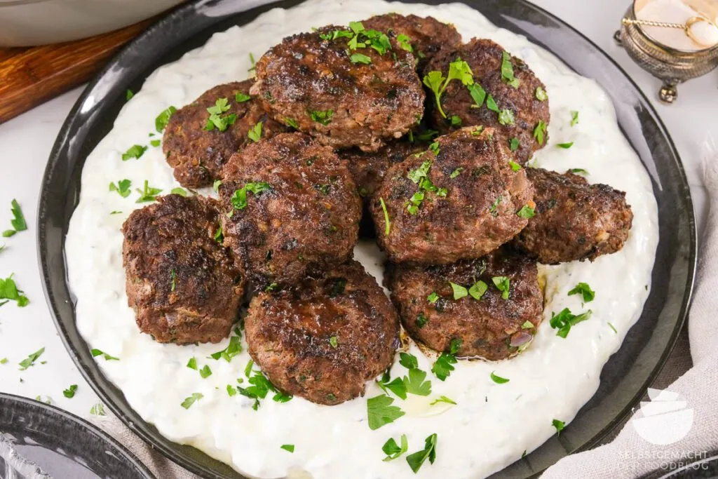 Köstliche türkische Köfte, perfekt serviert mit einer erfrischenden Schale Cacik als Beilage.