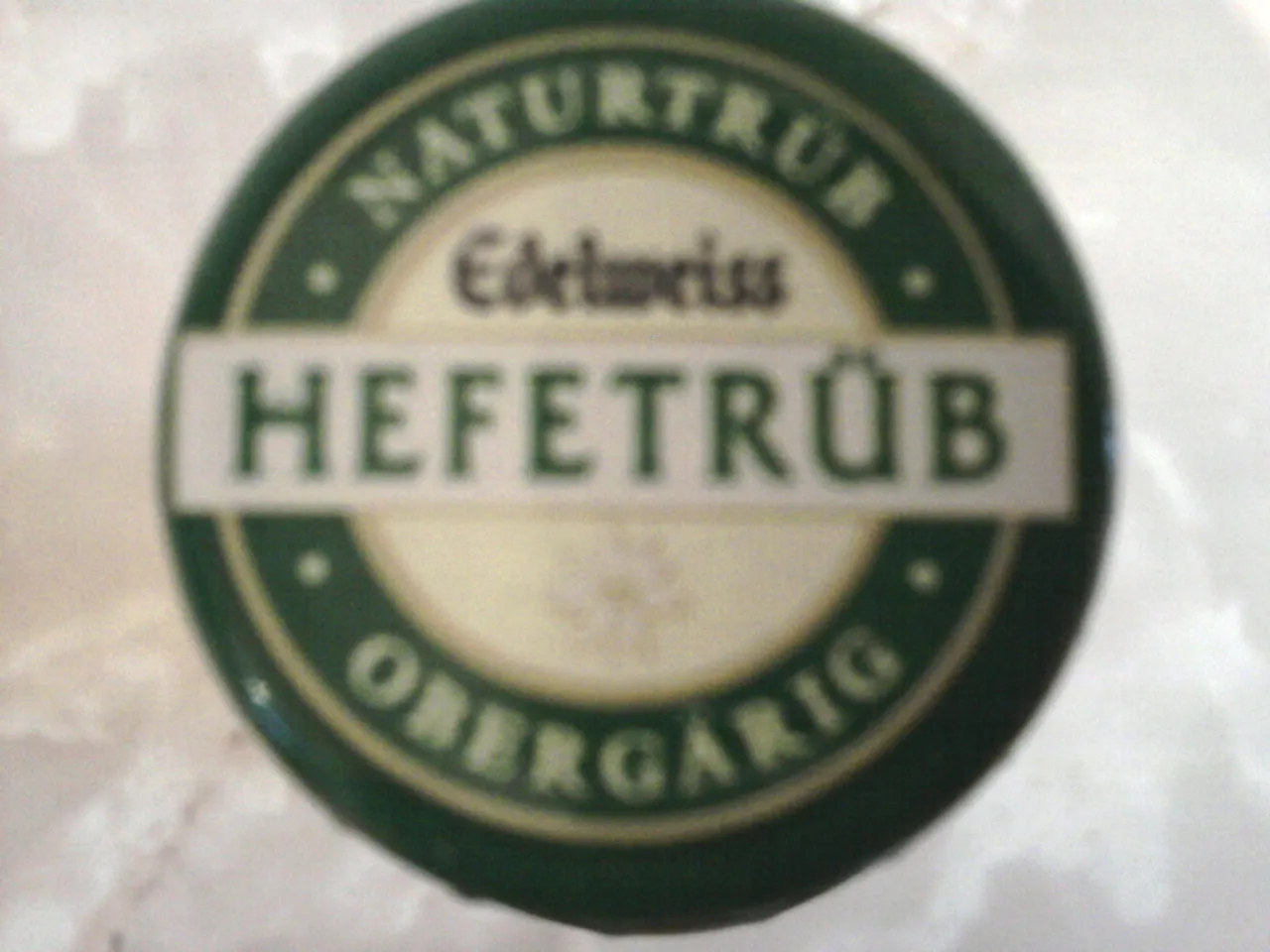 Kronkorken des Edelweiss Weizenbiers mit Aufschrift &quot;Naturtrüb Obergärig&quot;