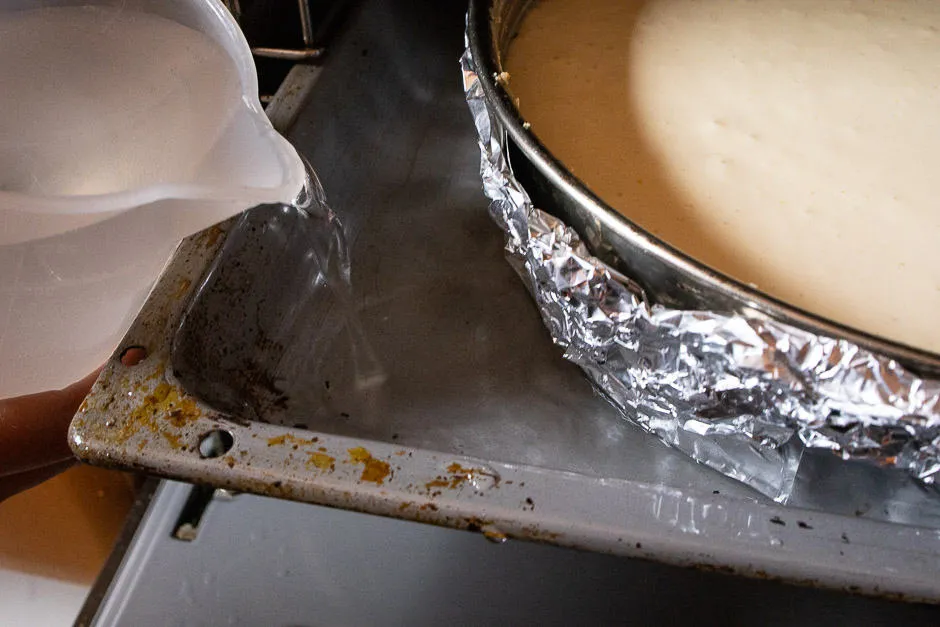 Kuchenform im Ofen vorbereitet für das Wasserbad mit eingegossenem Wasser