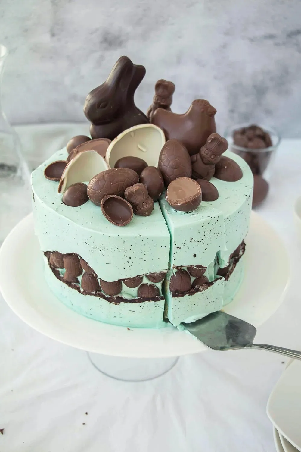 Künstlerische Sprenkelung der blauen Buttercreme auf der Fault Line Ostertorte mit einem Pinsel