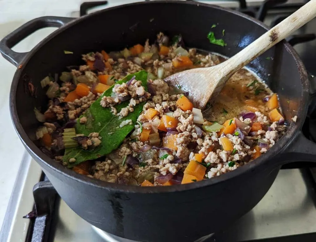 Lammhackfleisch wird mit Gemüse und Soße für die herzhafte Shepherd's Pie Füllung gekocht
