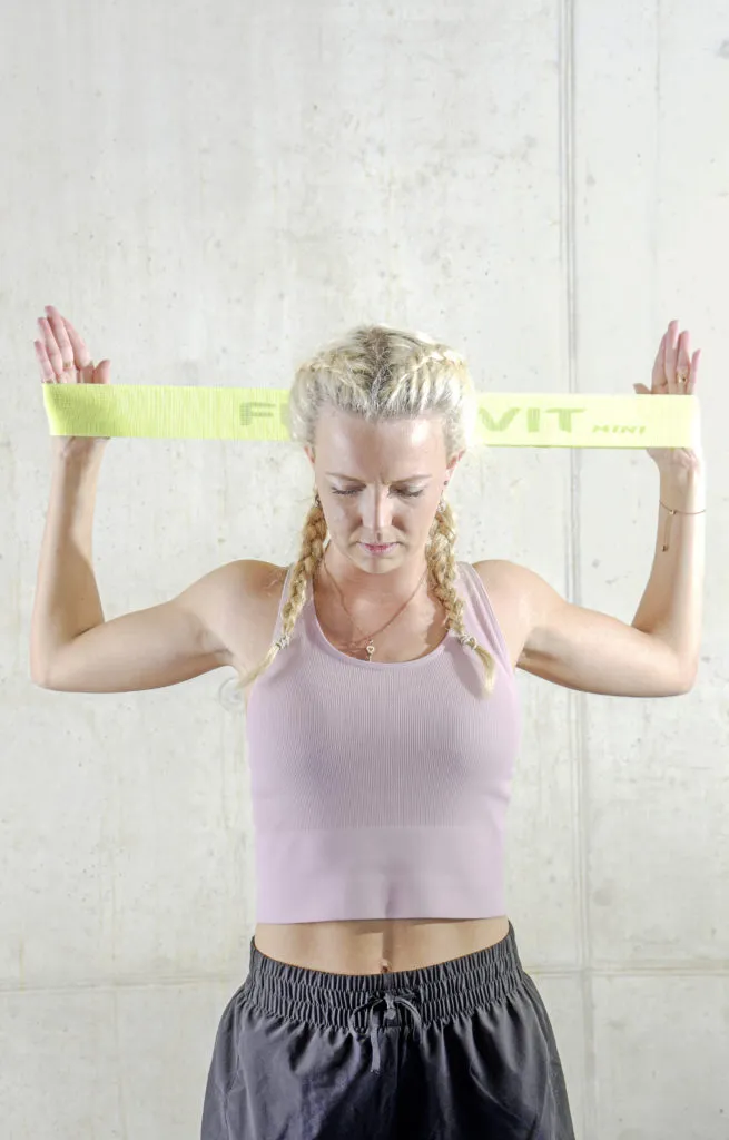 Latzug mit Miniband zur Stärkung der Arm- und Rückenmuskulatur, essenziell für Tennisschläge