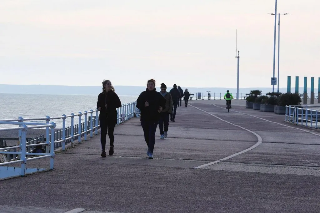 Läuferin in Bewegung auf einer Straße bei Sonnenuntergang, zeigt die Anstrengung und Notwendigkeit der Erholung nach dem Joggen