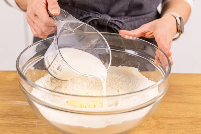 Lauwarme Milch zum Hefeteig gießen