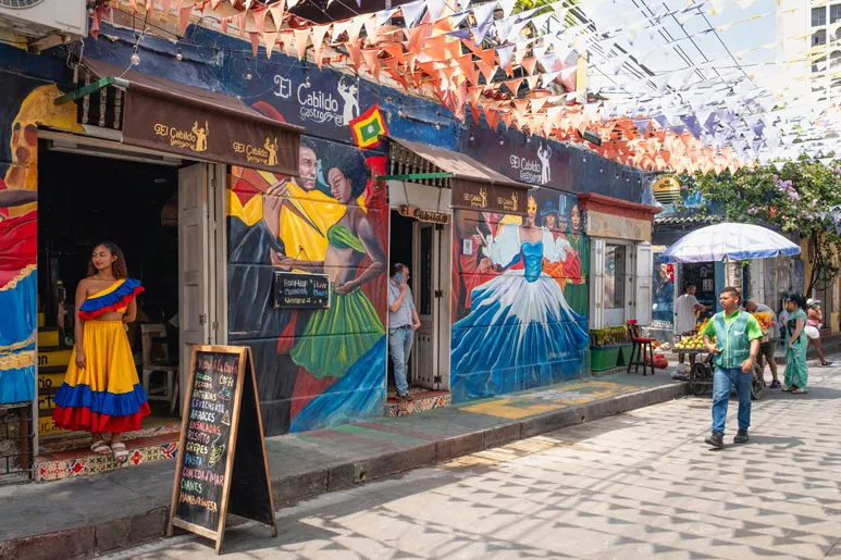Lebendige Straßenszene mit farbenfrohen Wandgemälden und flanierenden Menschen