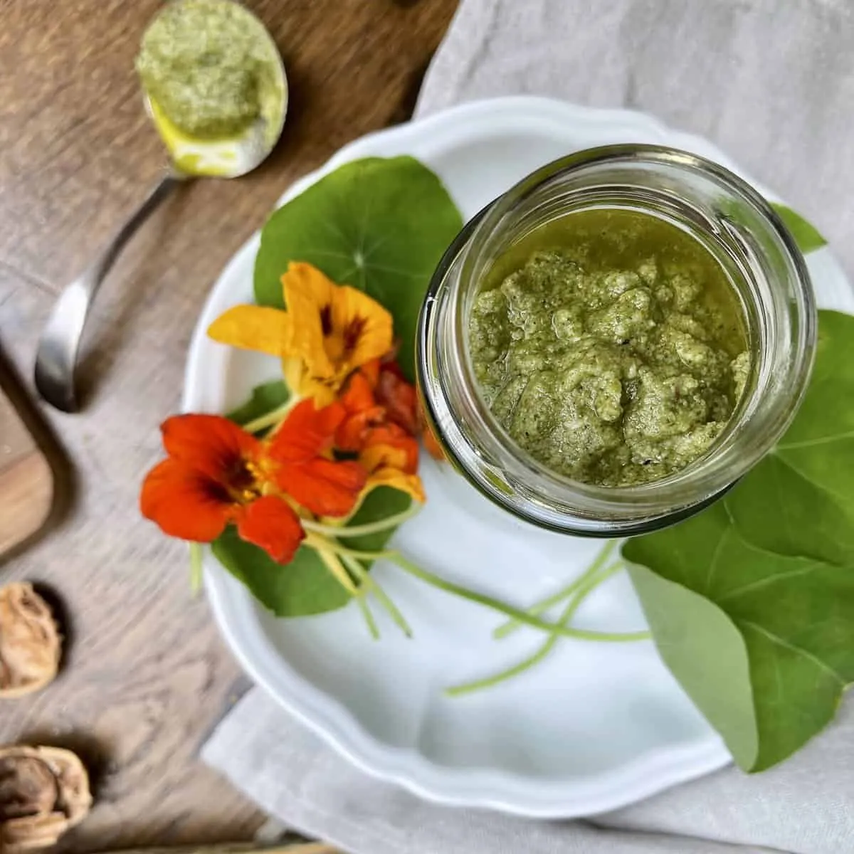 Lebendiges Kapuzinerkresse-Pesto in einem Glas, eine würzige Bereicherung für deutsche Mahlzeiten.