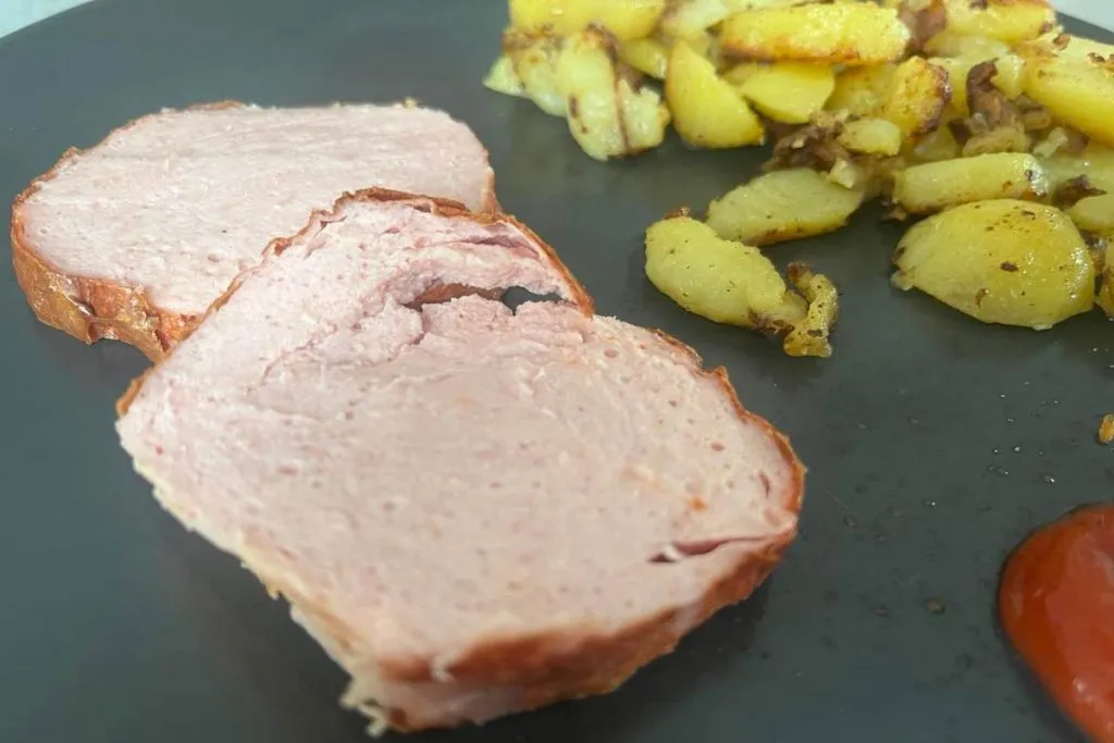 Leberkäse rustikal serviert mit Spiegelei und Bratkartoffeln