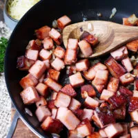 Leberkäse-Würfel werden zusammen mit gehackten Zwiebeln in einer Pfanne angebraten für schnelle gerichte mit Leberkäse