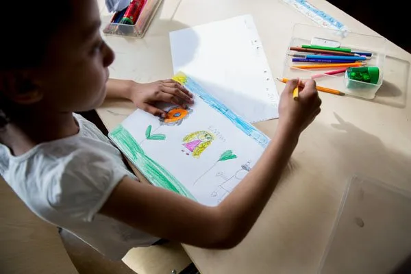 Lehrerin unterstützt Kinder mit Migrationshintergrund im Klassenzimmer, Beispiel für Integration im schwedischen Schulsystem