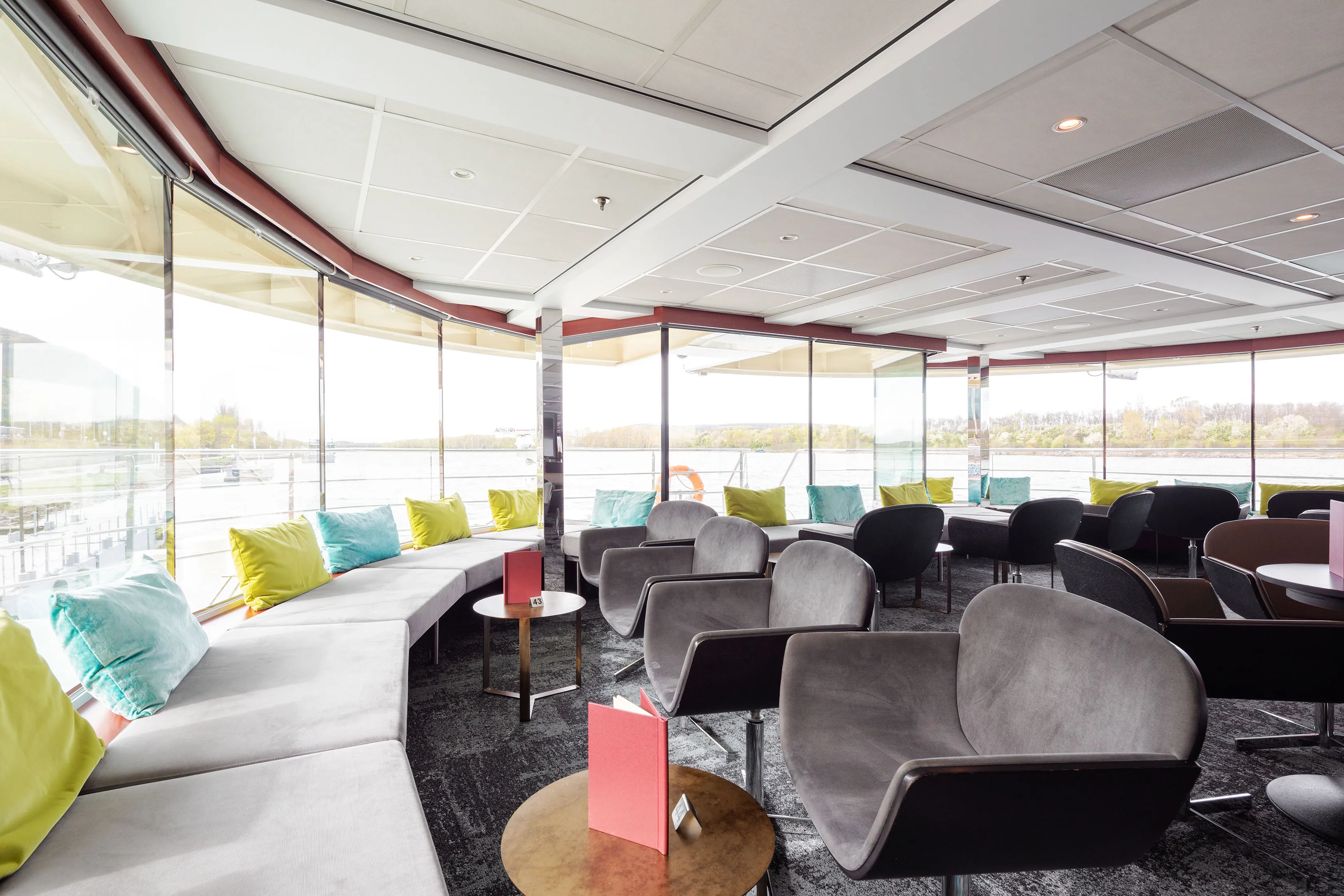 Lichtdurchflutete Panoramalounge der MS Nestroy mit weitem Blick auf die vorbeiziehenden Landschaften der Donau