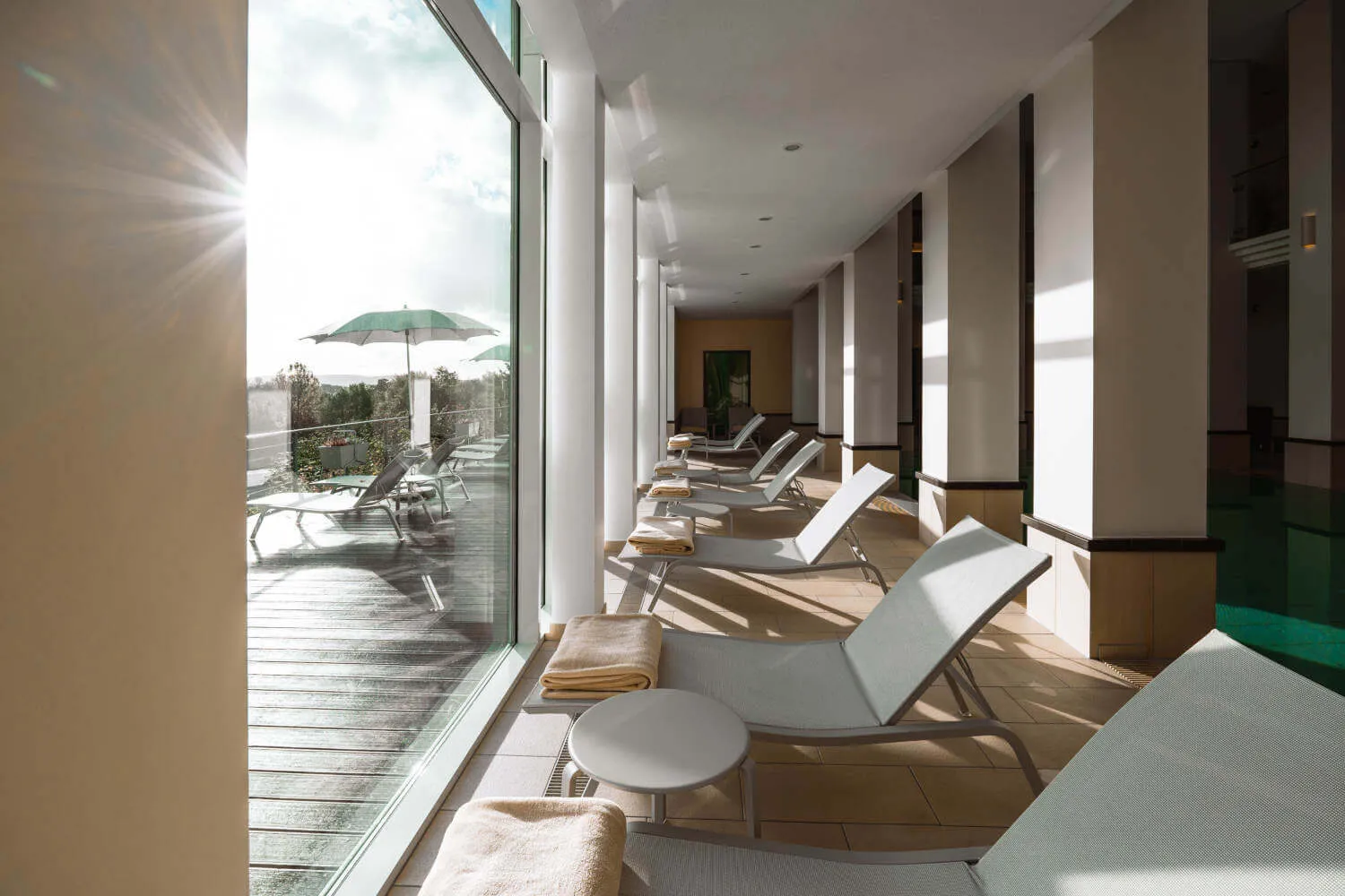 Liegen entlang der Panoramascheiben beim Innenpool des Hotel Diedrich, dem Wellnesshotel im Sauerland