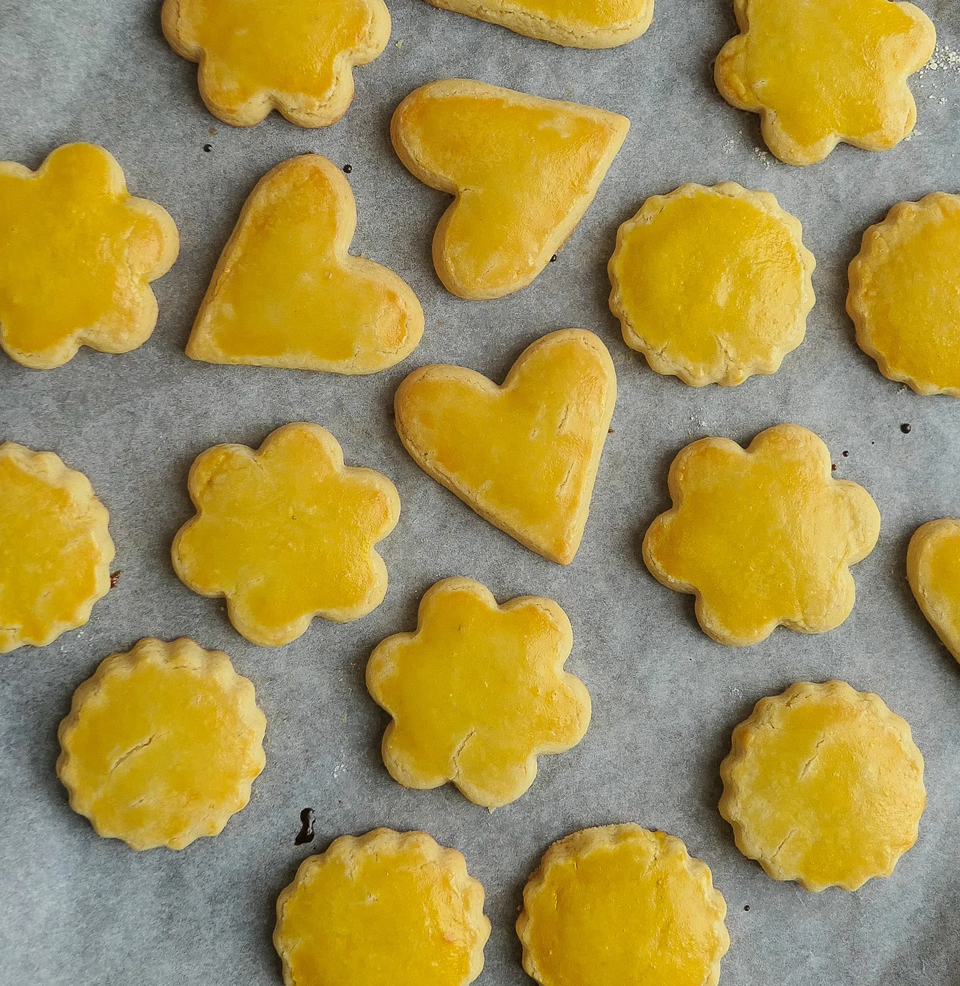 Mailänderli Gebäckstücke mit Zitronenaroma auf Backpapier