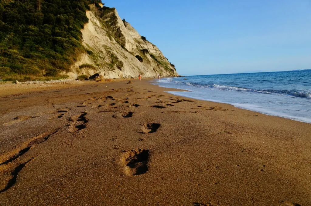 Malerischer Sandstrand auf Korfu mit türkisblauem Meer und üppiger Vegetation