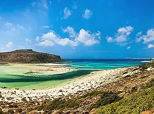 Malerischer Strand mit türkisfarbenem Wasser und grünem Ufer auf Kreta, Griechenland.