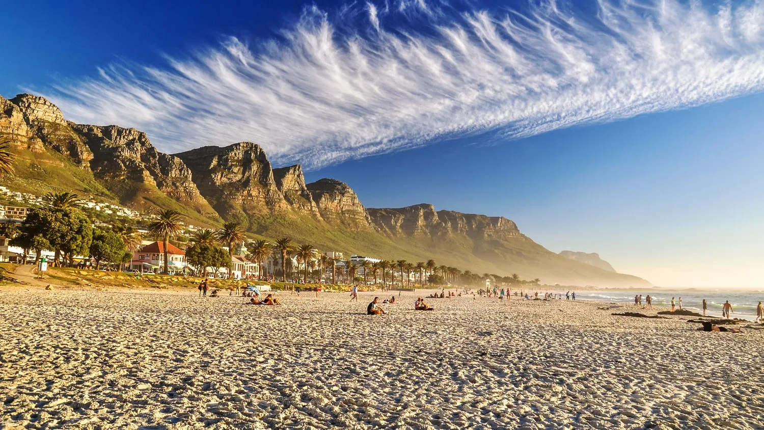 Malerischer Strand von Camps Bay bei Kapstadt mit den Zwölf Aposteln im Hintergrund, ideal für warme Reisen im März.