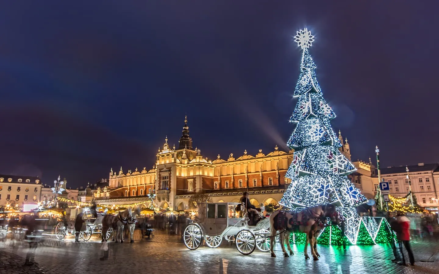 Malerischer Weihnachtsmarkt auf dem Rynek Główny in Krakau, Polen, mit festlicher Dekoration und Verkaufsständen.