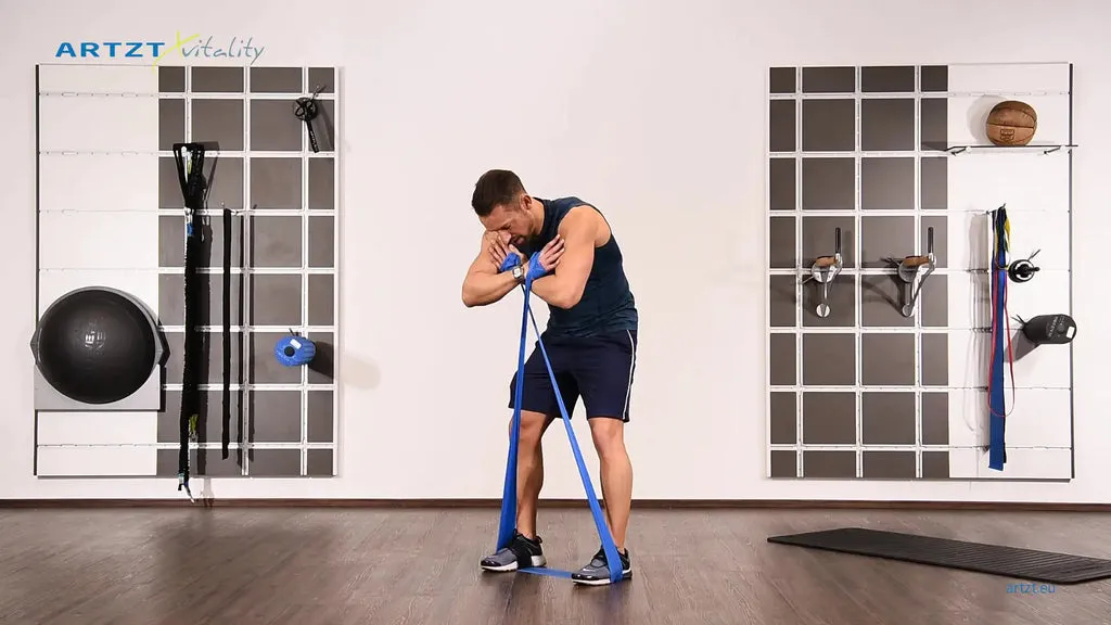 Mann vollführt die Übung Cat and Cow mit einem TheraBand.