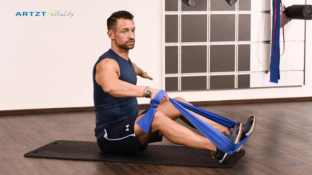 Mann vollführt die Übung Sitzendes Rudern mit einem TheraBand.