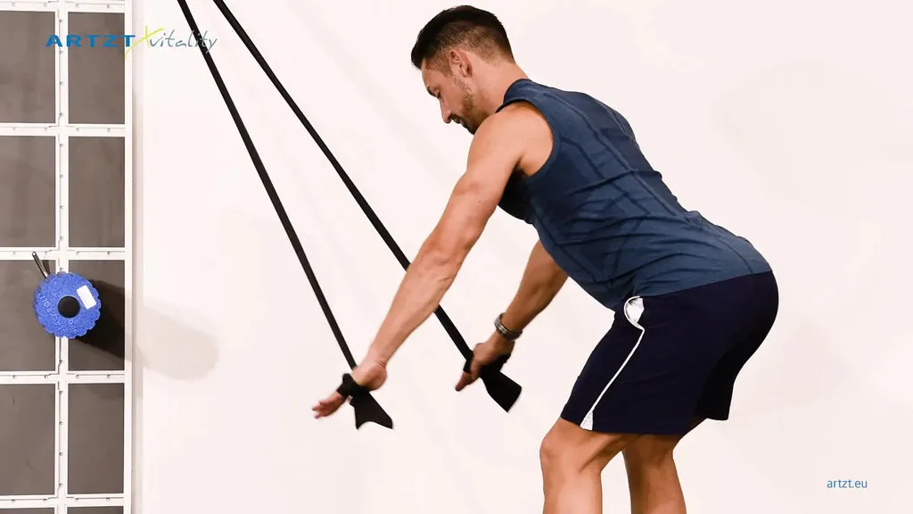 Mann vollführt die Übung Skispringer mit einem TheraBand.