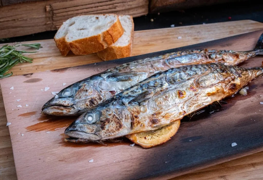 Maränen werden auf einem Räucherbrett gegrillt, um ein zartes Fleisch mit feinem Raucharoma zu erhalten.
