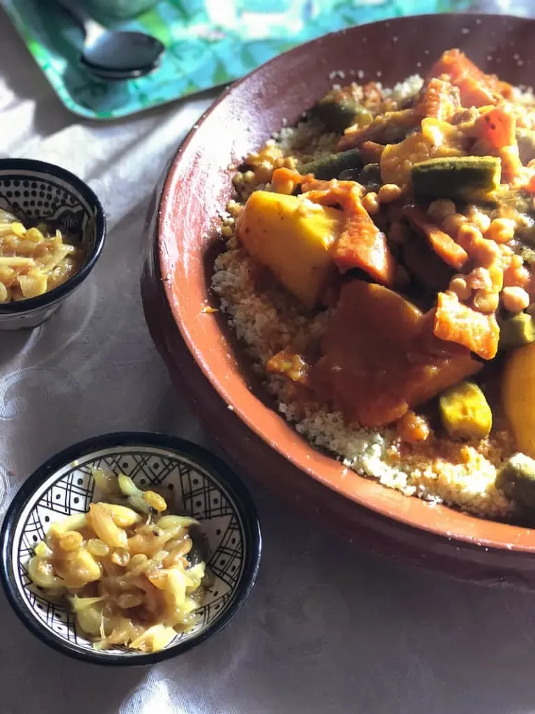 Marokkanisches Couscous mit Tfaya aus karamellisierten Zwiebeln, Rosinen und Gewürzen, appetitlich angerichtet.