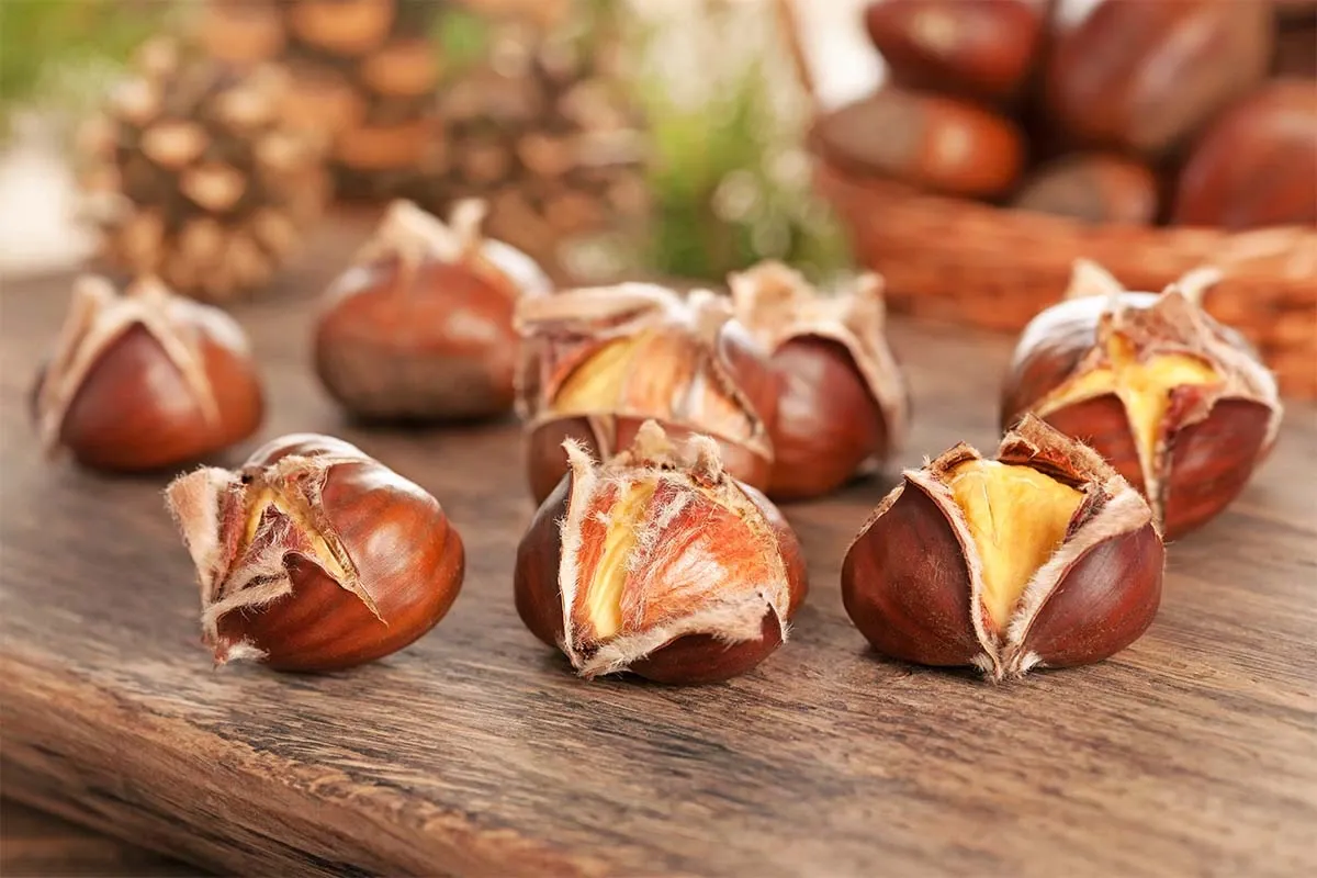Maronen liegen geroestet auf einem Holztisch