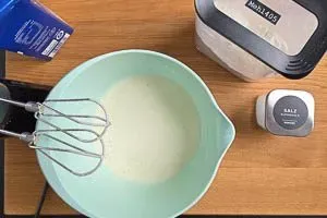 Mehl und Milch für den Pfannkuchenteig verrühren