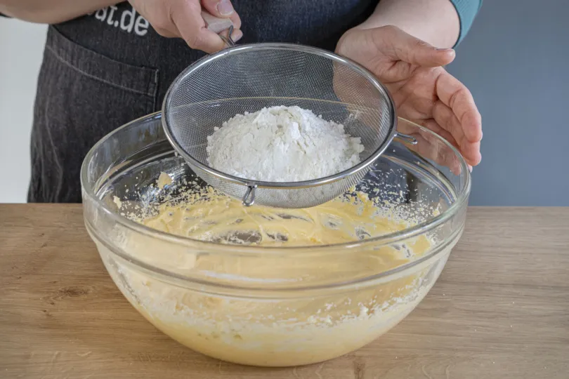 Mehl und Speisestärke in die Masse sieben