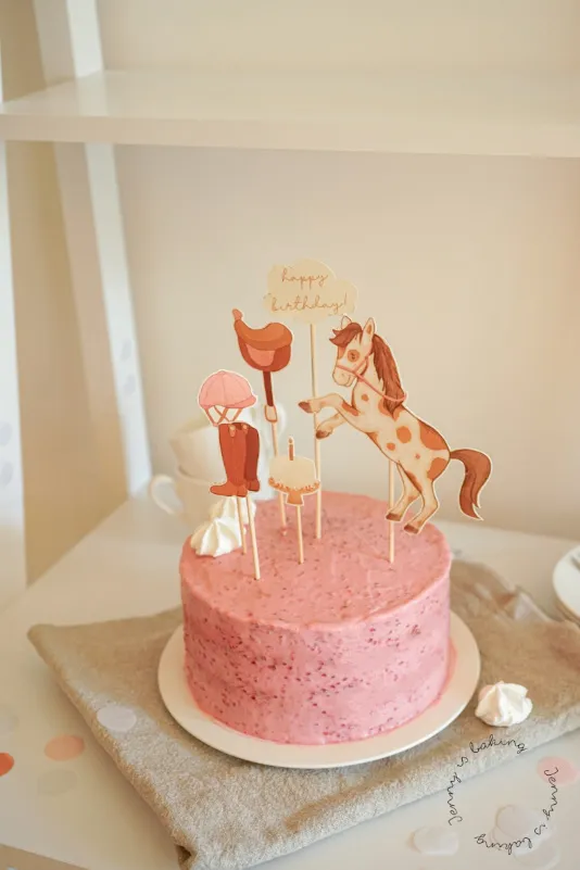 Mehrere kleine rosa Geburtstagskuchen, verziert mit thematischen Tortenauflegern, ideal für eine Feier