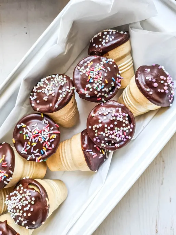 Mehrere Mini-Kuchen in Waffelbechern auf einem Backblech