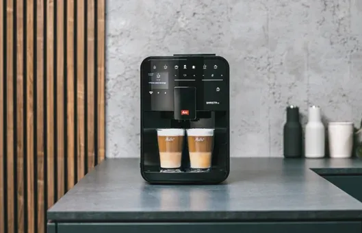 Melitta Barista SE bereitet zwei geschichtete Latte Macchiato in einer stilvollen Küche zu.