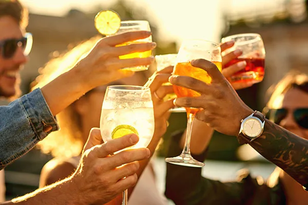 Menschen stoßen mit Drinks an