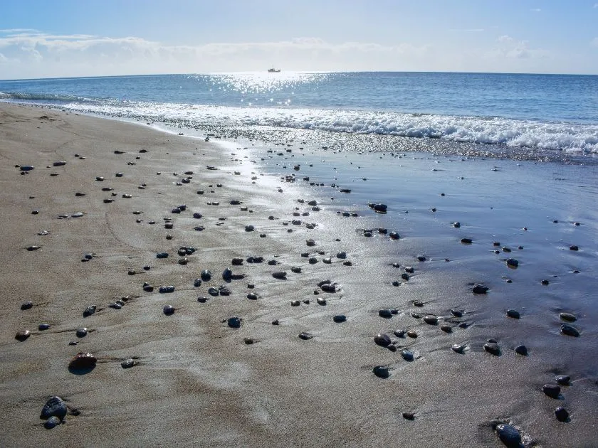Mero Beach auf Dominica mit dunklem Sand und klarem Meer