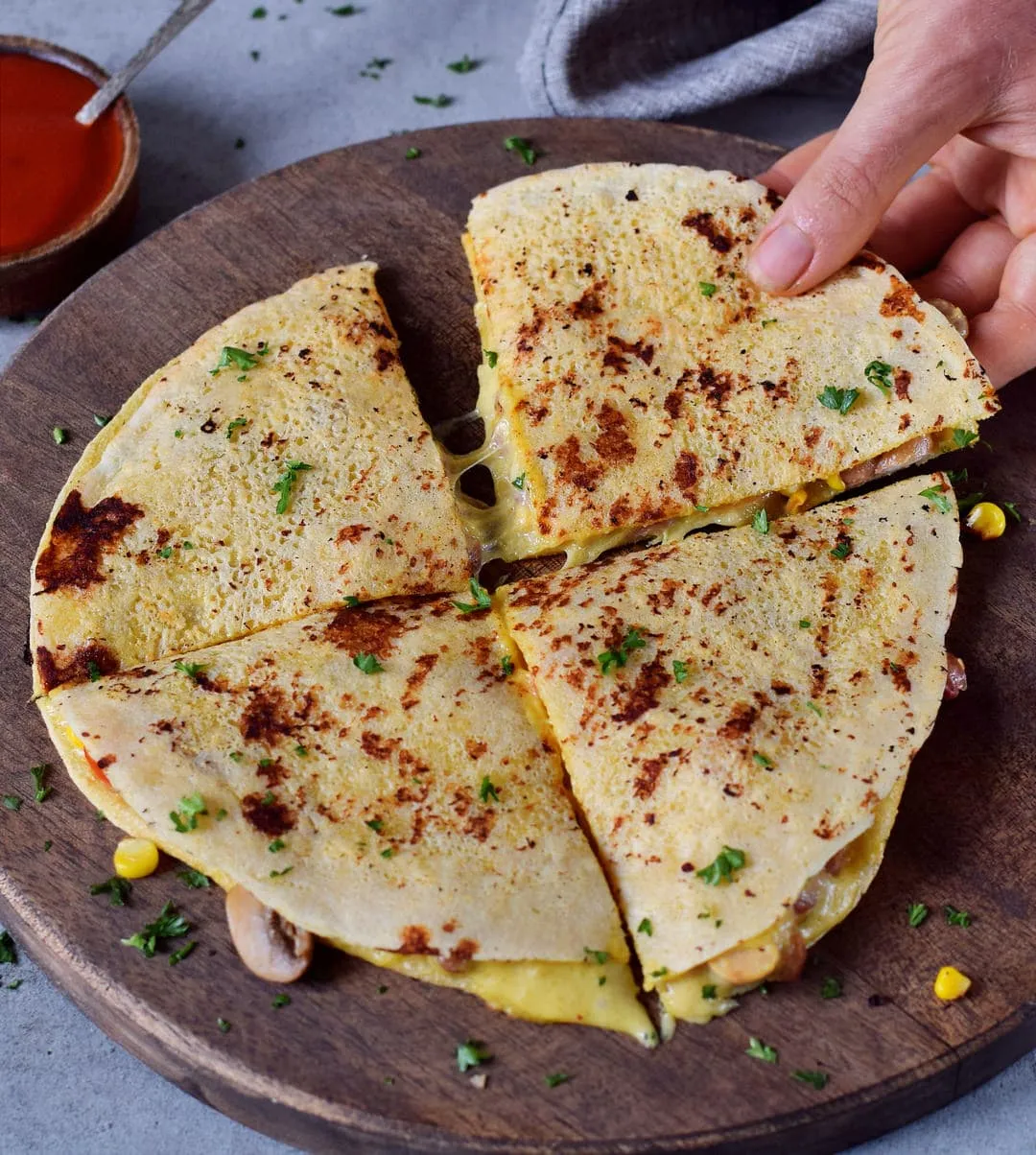 Mexikanische vegane Quesadillas mit Gemüse, schwarzen Bohnen und Käsesoße auf einem Schneidebrett, ein schnelles Mittagessen.